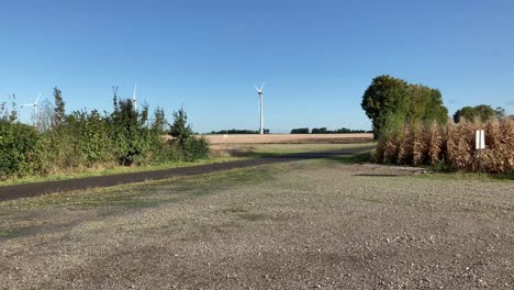 Shadow-of-a-wind-turbine-which-is-turning-in-the-wind-with-a-turbine-in-the-distance-against-a-blue-sky