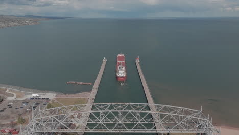 aerial, cargo ship sailing from duluth harbor into lake superior