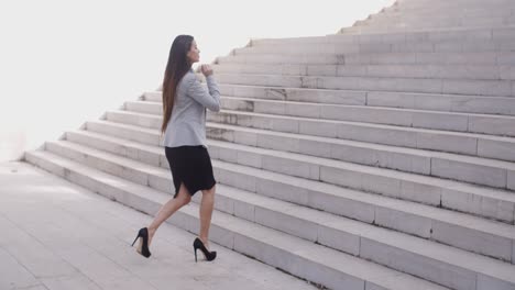 Serious-woman-walking-up-staircase