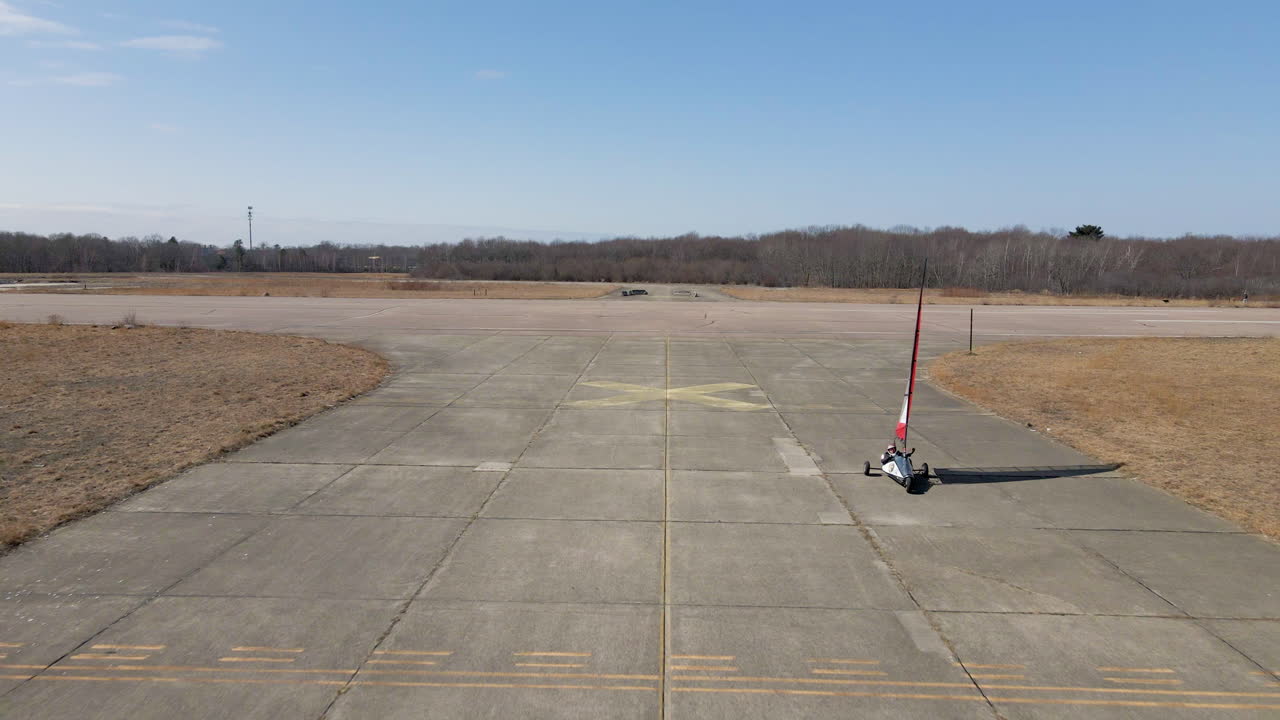imágenes aéreas de un buggy de navegación terrestre tomando curvas y luego el dron retrocediendo para seguir al yate.