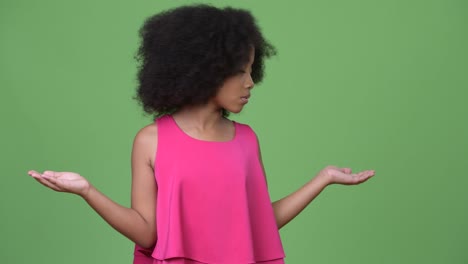 una joven africana con cabello afro eligiendo entre la izquierda y la derecha
