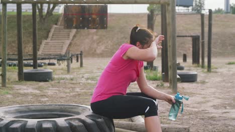 caucasian woman resting after exercising at bootcamp