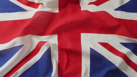 Video-of-creased-flag-of-great-britain-lying-on-white-background