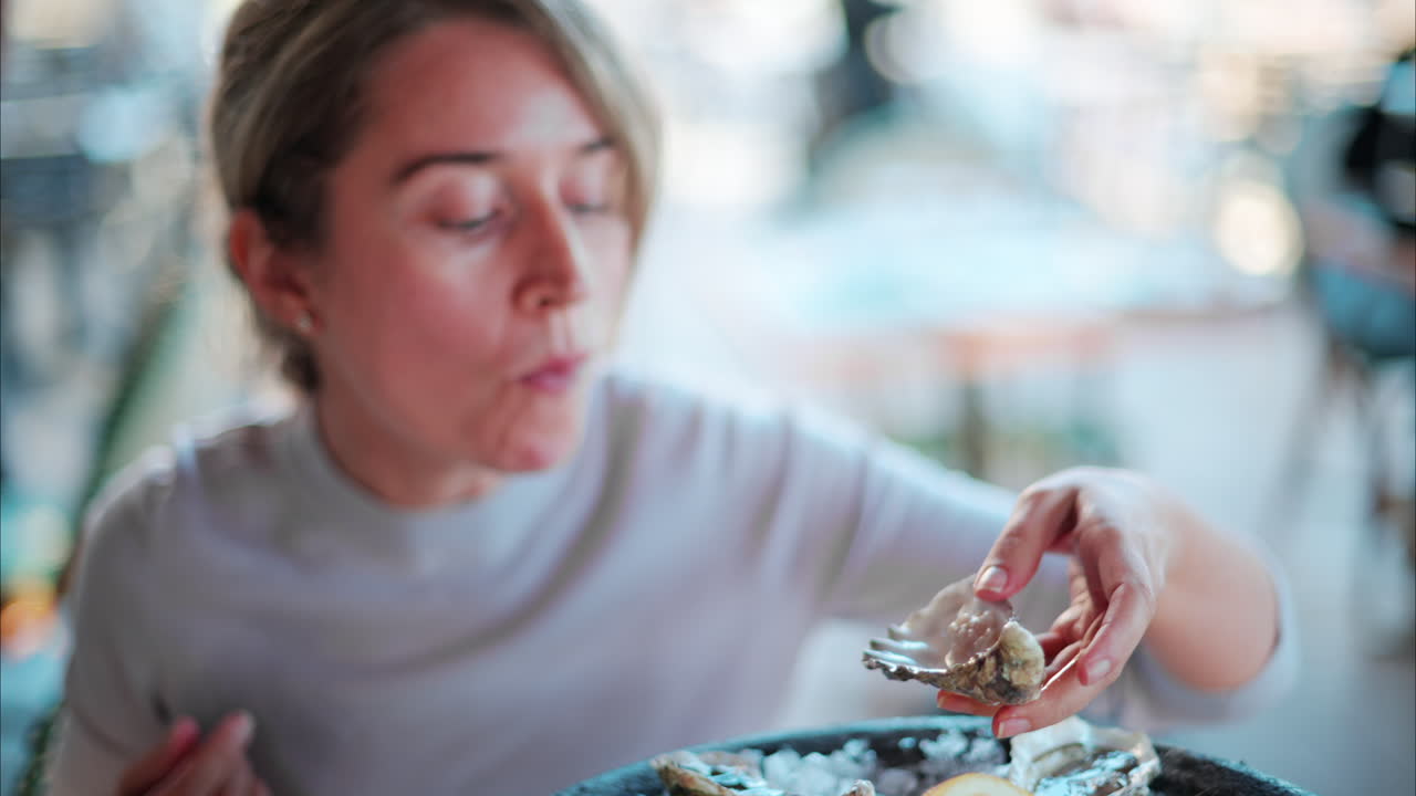 Woman eating raw oyster at a restaurant