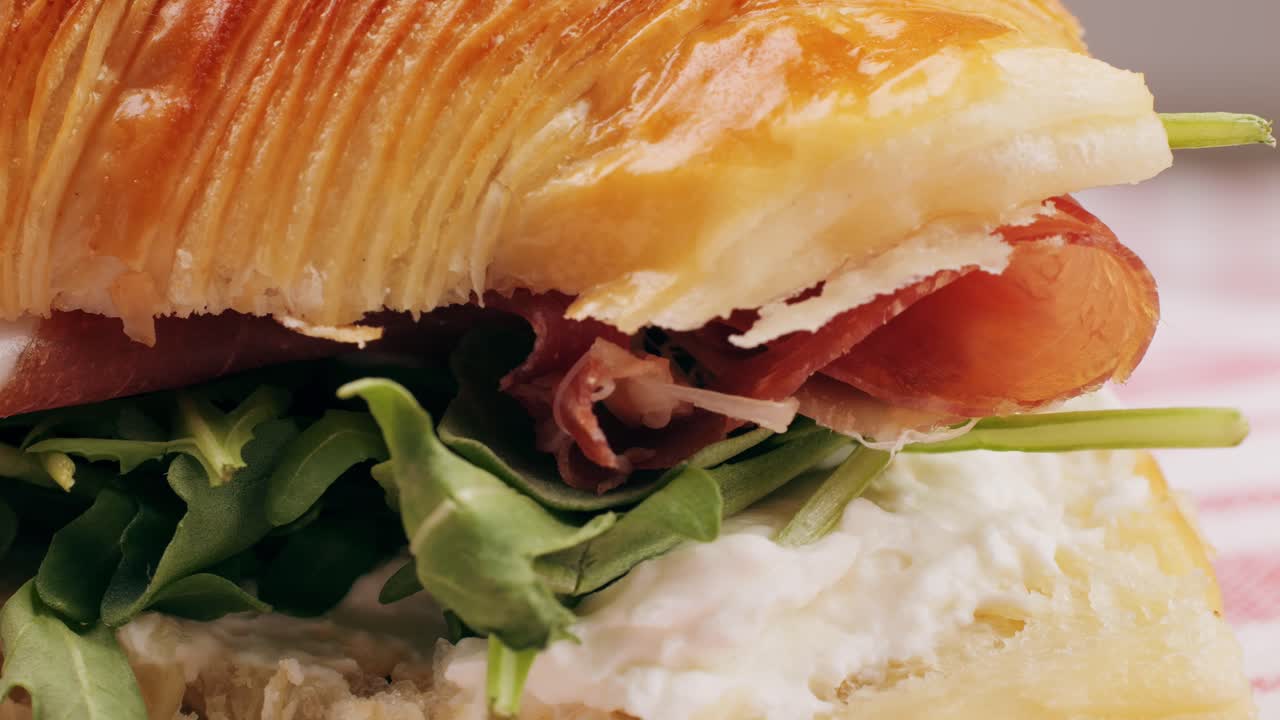 Croissant with jamon ham, Salmon, in Modern Cafe, Top View of Healthy Breakfast in Cafe. English breakfast: fried egg, bacon toast on sandwich.