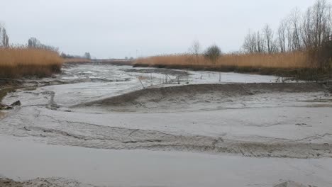 Empuje-En-Antena-Ascendente-Lecho-De-Río-Seco-Día-Lluvioso-Charco-De-Barro-Paisaje