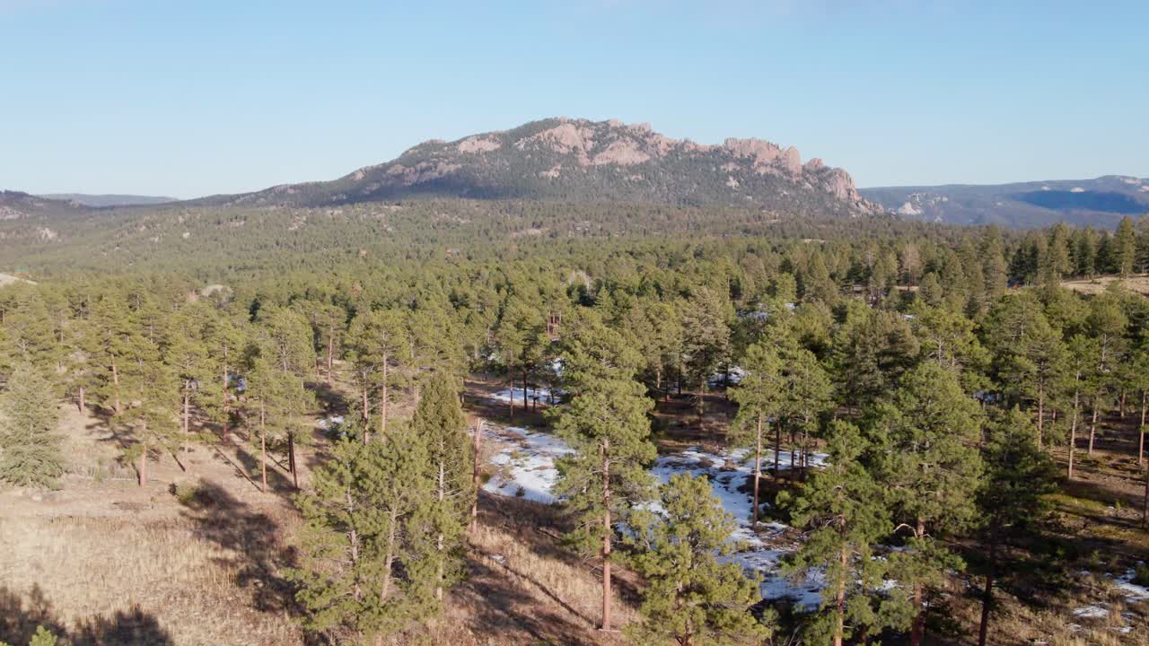 Aerial drone view of the Pike National Forest and Long Scraggy Mountain in winter. Trucking to the rear. Filmed in the Rocky Mountains of Colorado.