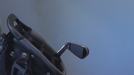 close-up of a golfer wearing a glove putting back multiple golf clubs into a bag