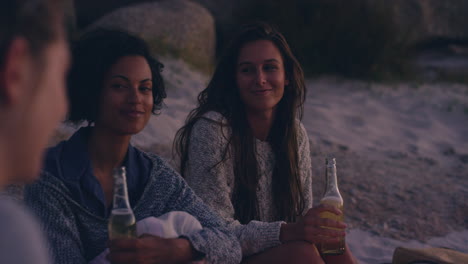 Beach-bonfire-with-group-of-friends,-drinking-beer-and-playing-guitar