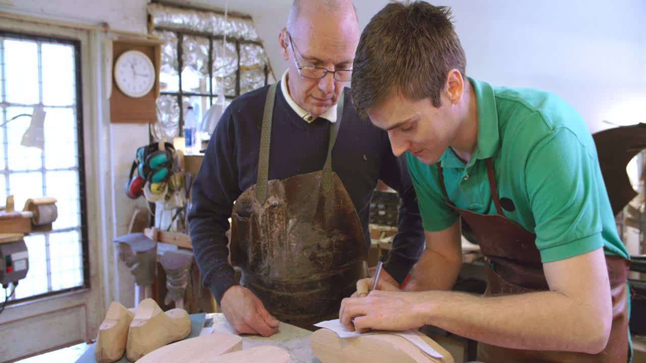 aprendiz en zapateros a medida dibujando plantilla para el último