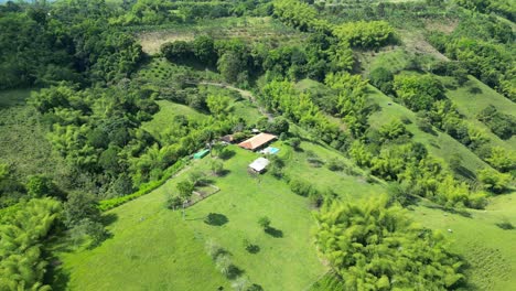 Vista-Aérea-De-Finca-Rancho-Con-Piscina-En-La-Cima-De-Una-Colina-Verde-Y-Exuberante-En-Colombia