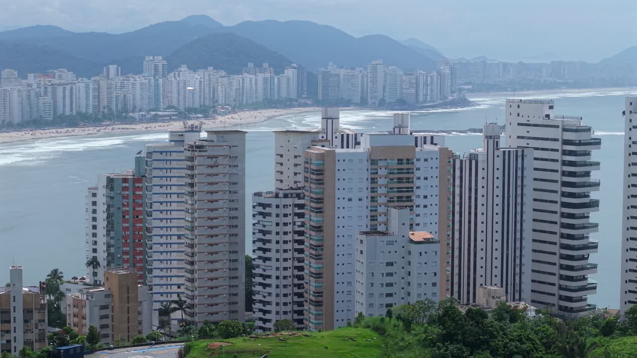Vista Aérea de torres de condomínios de luxo à beira-mar no Guarujá, Brasil. Imóveis Costeiros.
