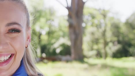 Portrait-of-happy-caucasian-woman-looking-at-camera-in-park,-slow-motion