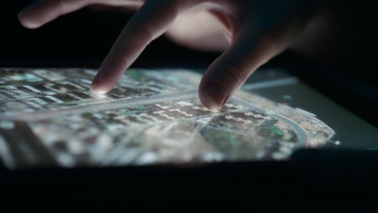 Person rotating a satellite view map on a tablet using fingers