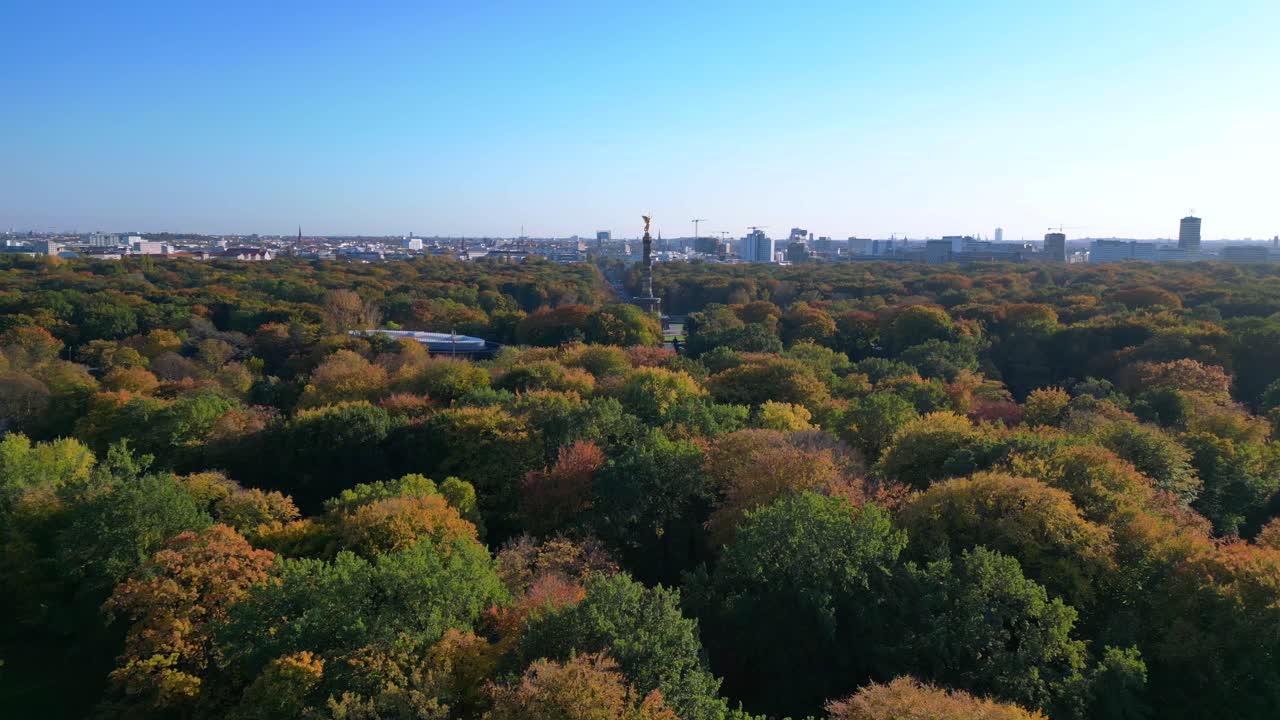 iconic berlin victory column rising above the vibrant autumn foliage of tiergarten park, with the cityscape in the background. Unique aerial view flight overflight flyover drone