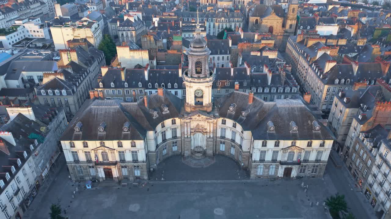 Drone pulling back above Rennes City Hall and its square at sunrise