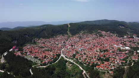 beautiful aerial wide shot of the krushevo city in macedonia which is in a valley surrounded by forest and nature