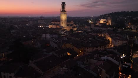 La-Rotación-Aérea-Revela-Una-Toma-De-Drones-Del-Horizonte-De-Verona-Por-La-Noche-Con-Puesta-De-Sol,-Hasta-El-Campanario-De-La-Catedral-Principal