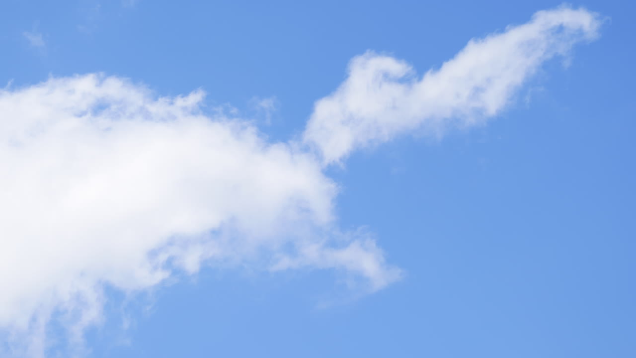 Puffy Cumulus Clouds rolling across a bright blue sky on a clear day