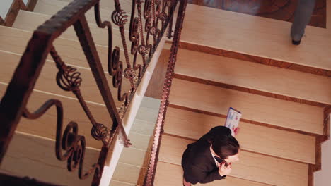 Top-view-of-stressed-businesswoman-discussing-on-smartphone