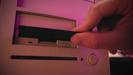 inserting floppy disk into vintage computer