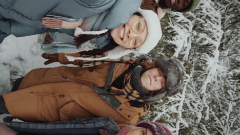 pov of happy friends smiling and waving at camera in winter forest