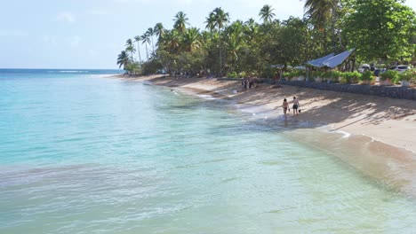 turistas caminando por la costa de playa punta popy, las terrenas en república dominicana