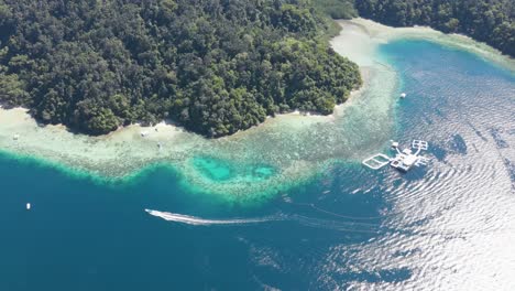 aerial flying over vibrant turquoise waters off tropical gaya island off kota kinabalu