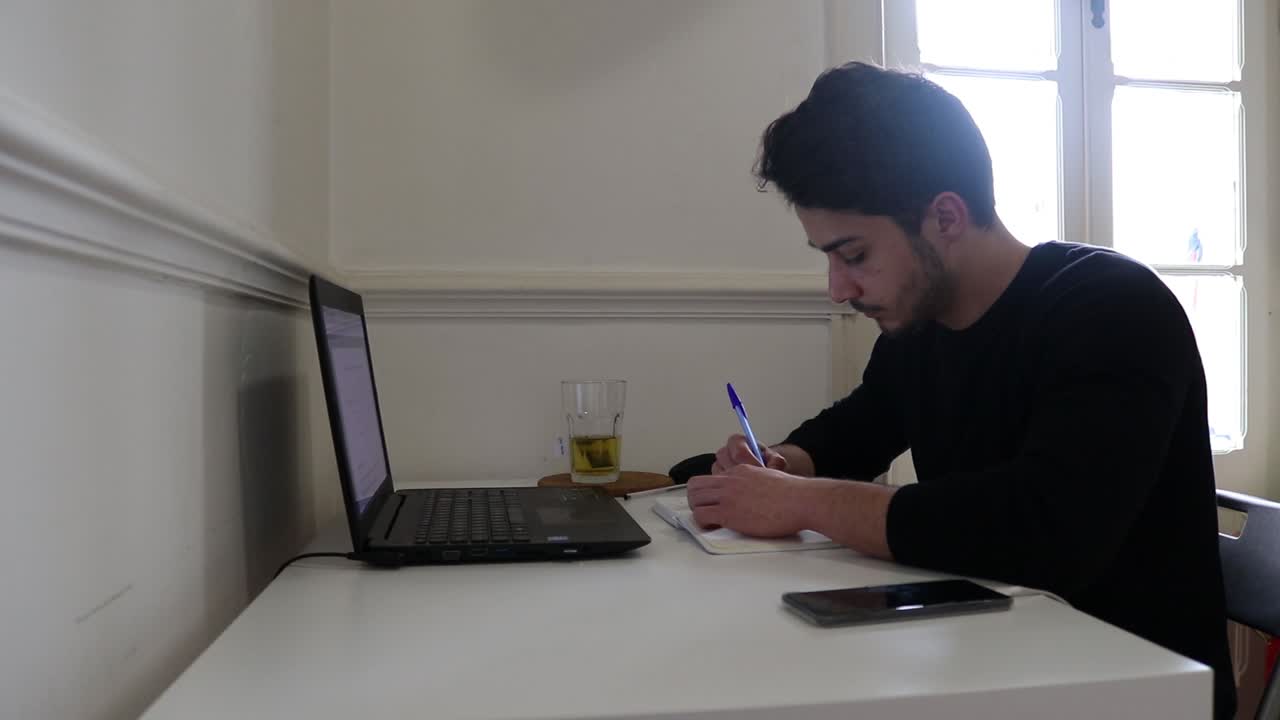 Young adult studying for exams at home.