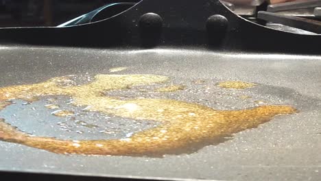 scrolling shot, pouring pancake batter on to hot pan, butter melting, in the morning