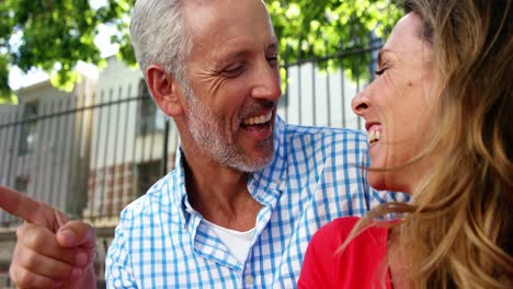 Mature-couple-is-sitting-in-the-street-and-laughing-