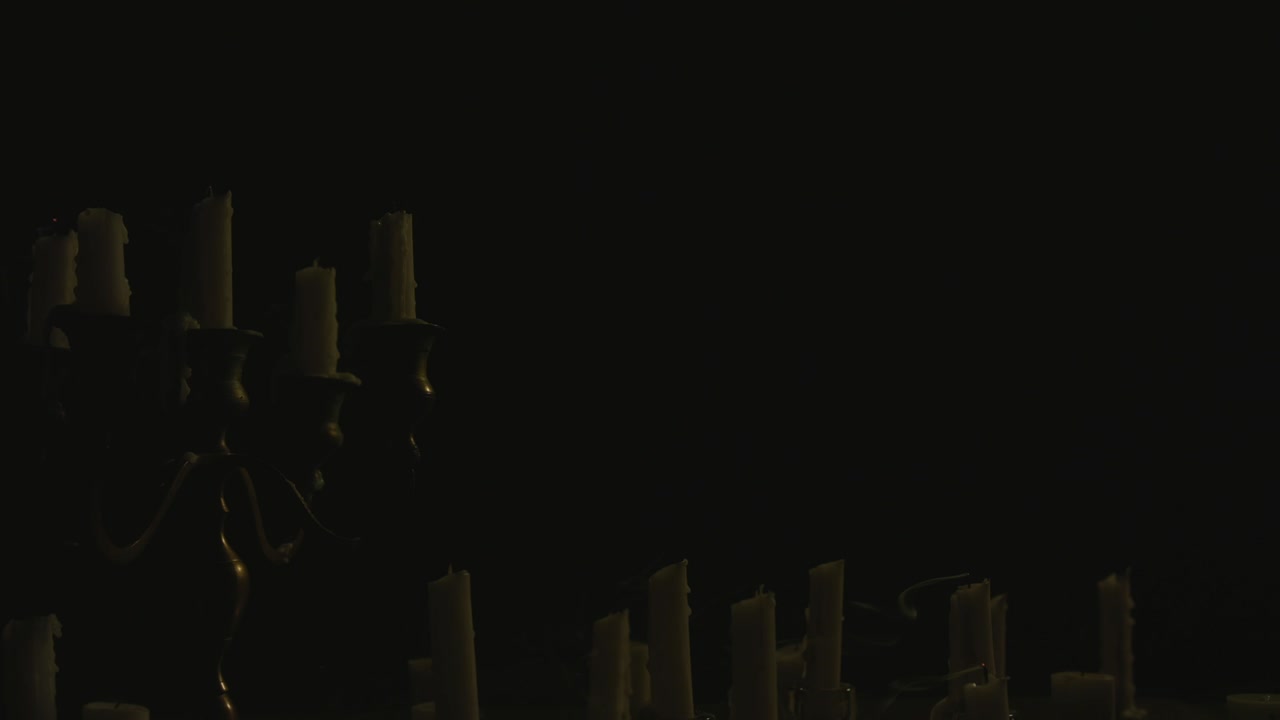 촛대에 있는 하얀 양초 그룹이 불을 붙인 다음 바람에 날려