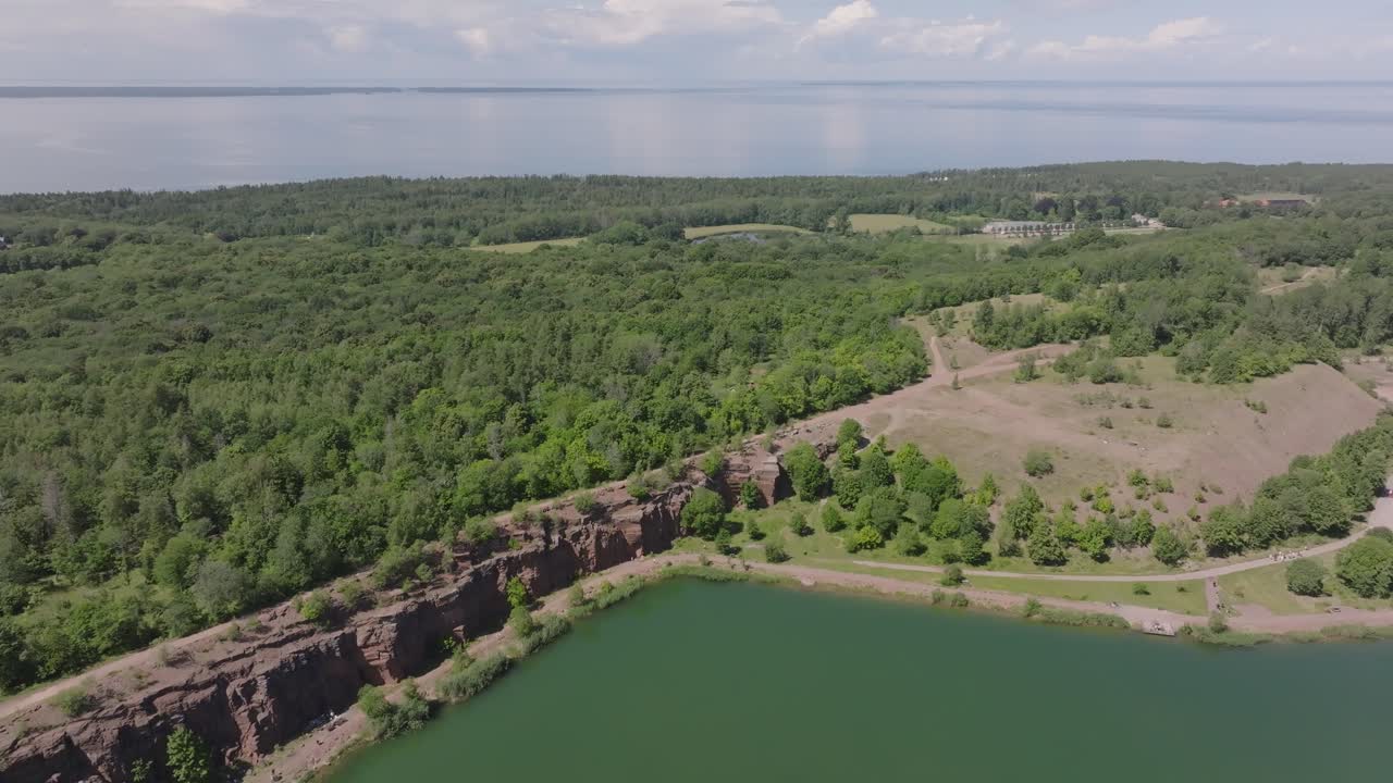 красные скалы и лесные деревья в карьере киннекулле стенбротт в швеции