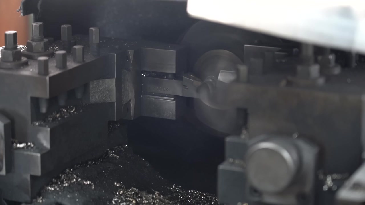 Automated milling machine cuts a steel workpiece as bright metal chips spray across the machine bed