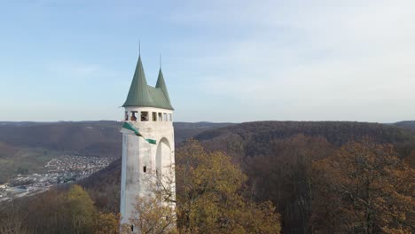 vista aérea cercana de una antigua torre en el jura de suabia con una bandera ondeando en cámara lenta