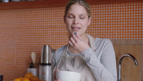 young caucasian woman eating blueberries for breakfast enjoying healthy organic lifestyle relaxing at home