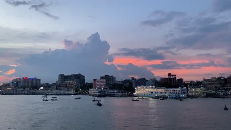 river-with-boats,-urban-city,-ship-terminal-during-twilight-sunset