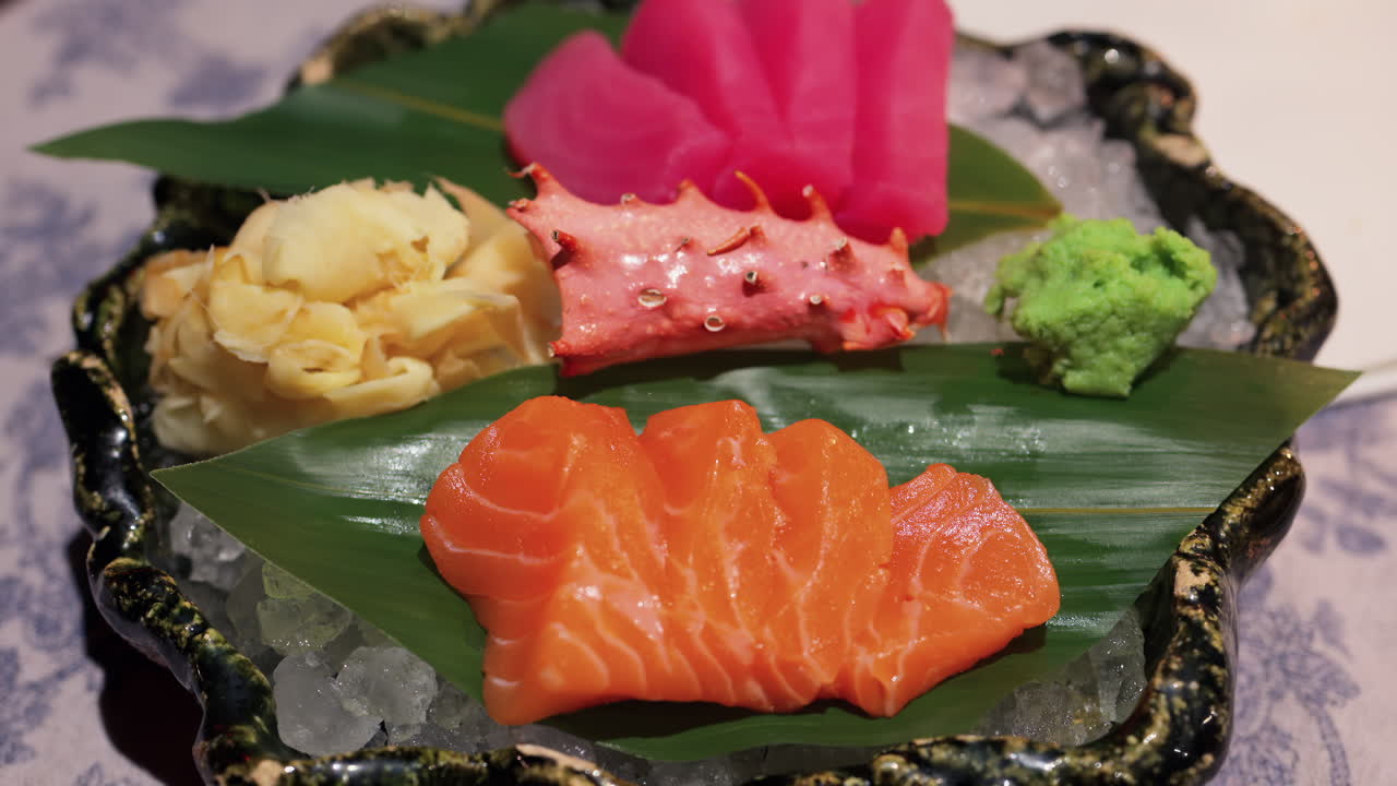 Close up of tuna and salmon sashimi on banana leaves on ice