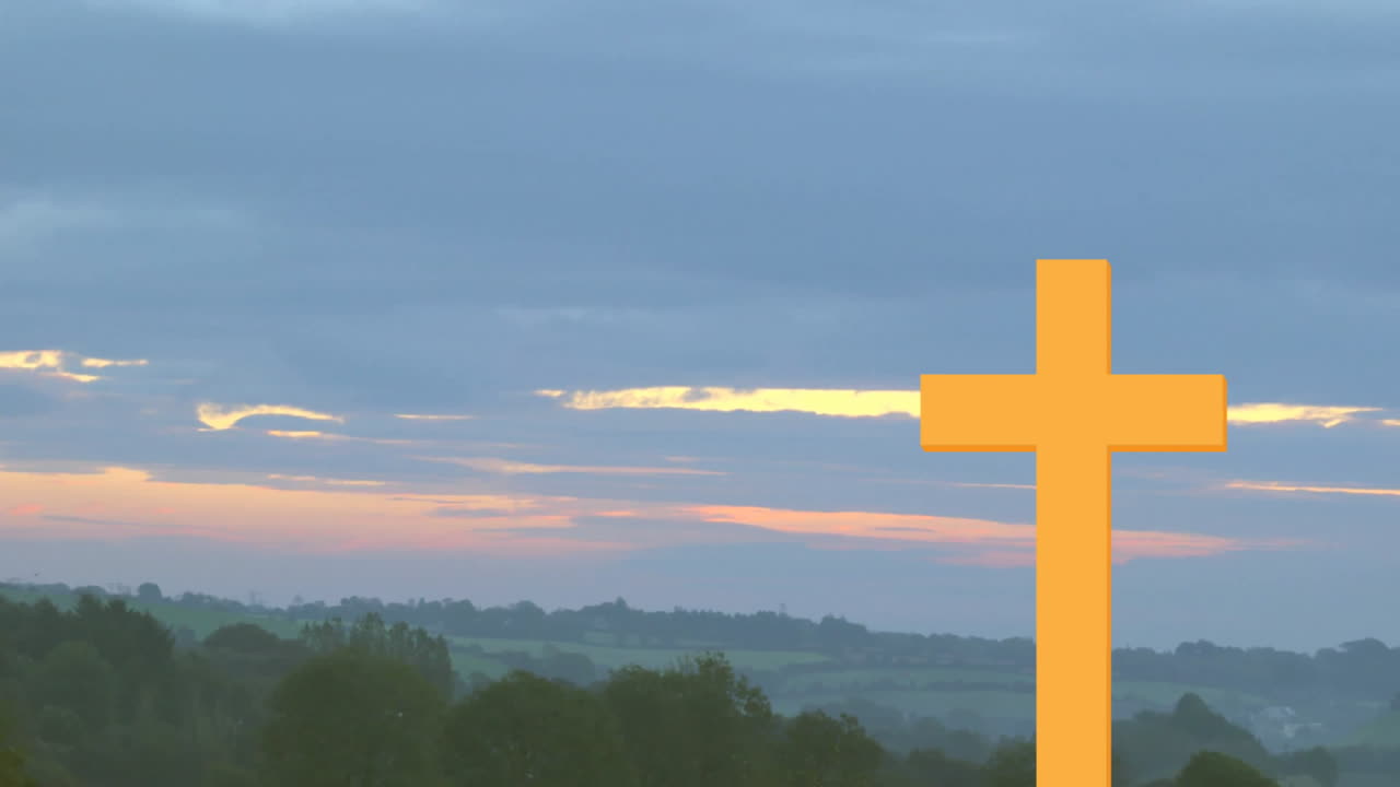 Large orange cross in foreground with sunset over countryside landscape