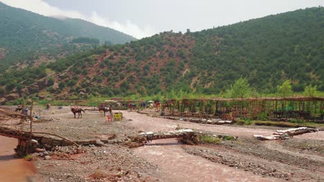 Restaurants-and-horses-at-Oued-Rheraya-river-basin,-Morocco,-High-Atlas