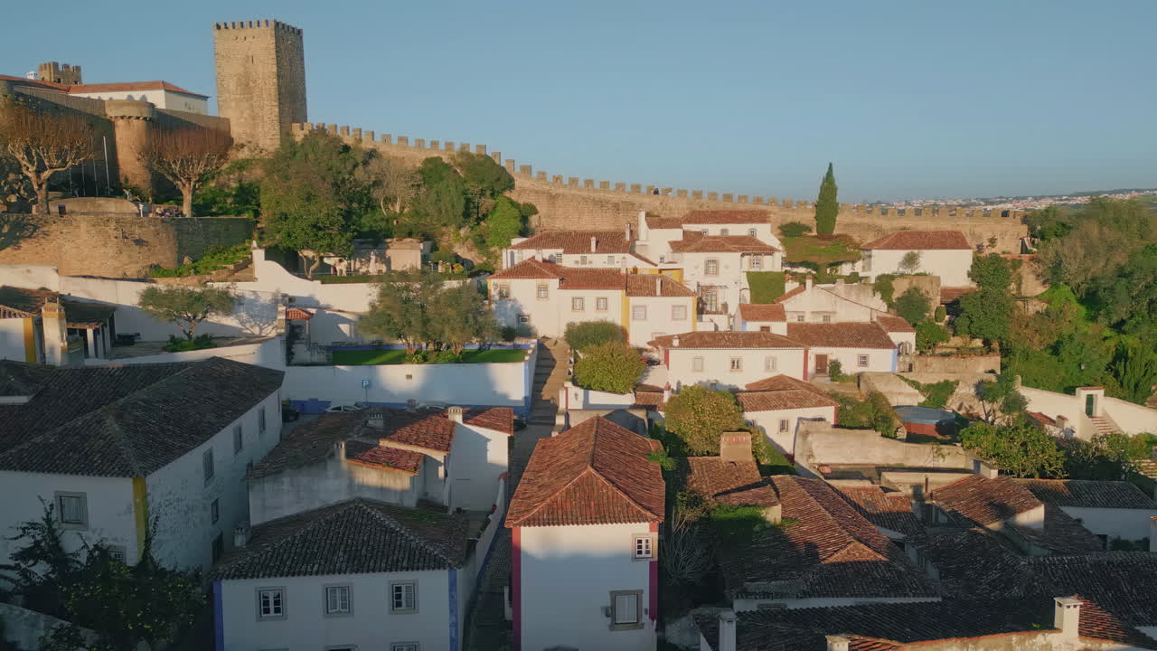 Castle walls rising town medieval rooftops aerial view. Scenery historic village