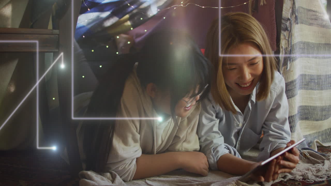анимация огней, падающих на счастливую азиатскую мать и дочь с помощью планшета