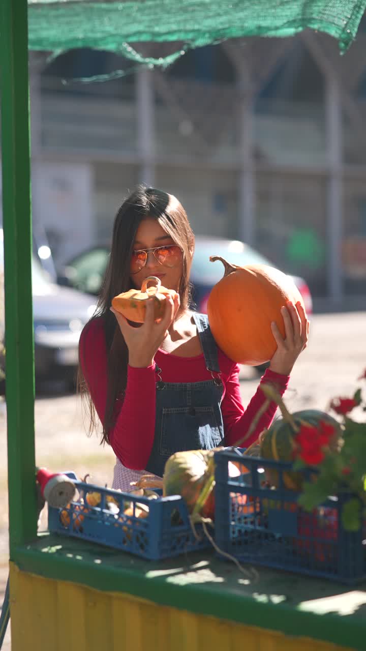 mujer seleccionando calabazas en un mercado de agricultores
