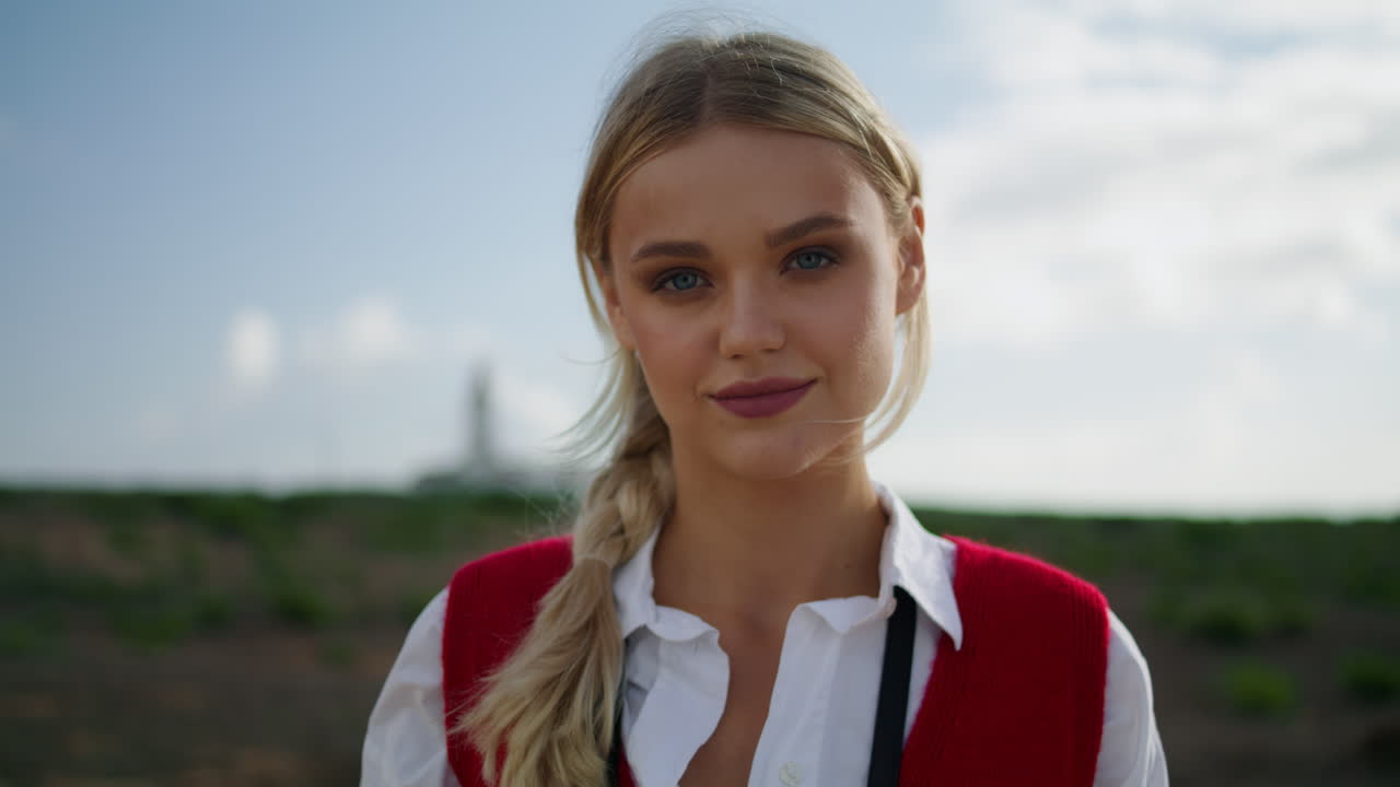 행복한 여성이 자연의 초상화로 포즈를 취하고 있습니다. 금발의 평온한 소녀가 혼자 서있는 초록색 필드