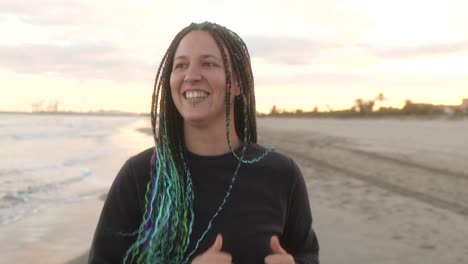 mujer con trenzas corriendo por la playa con una sonrisa