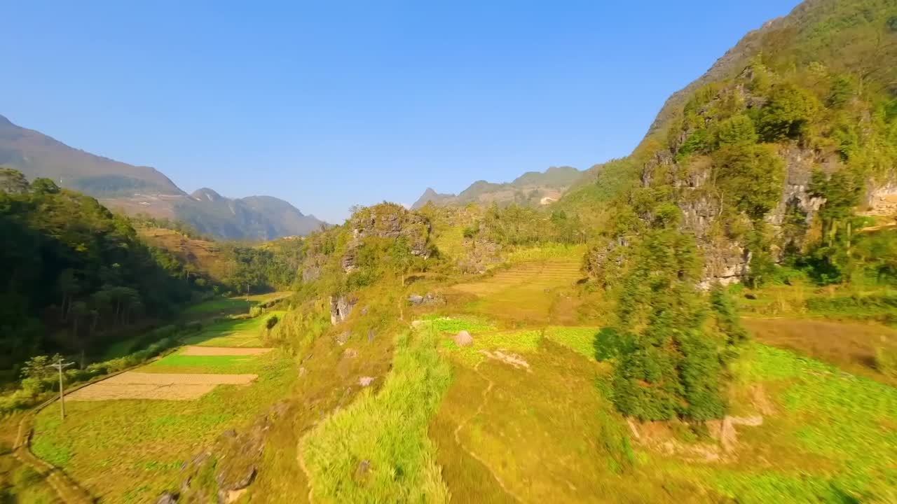 Scenic drone view of a fertile valley with forested hills, rock formations, and farmland, ideal for nature, agriculture, adventure travel, and rural tourism themes.
