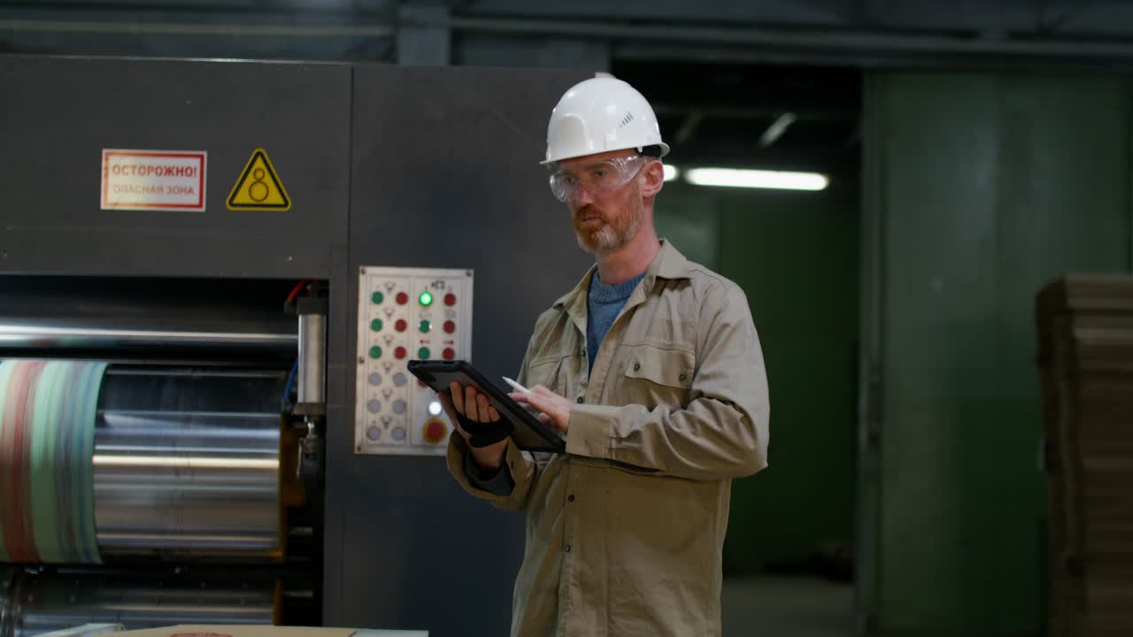 Factory Worker Inspecting Machinery and Production