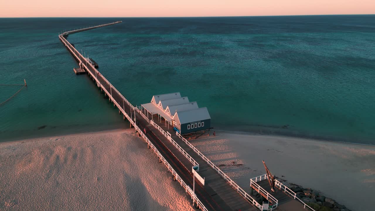 서쪽 오스트레일리아의 버셀턴 제티 (busselton jetty) 주변에서 해가 지고 해변이 전면에, 인도양이 배경에 있습니다.