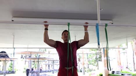 man performing pull-ups with resistance bands