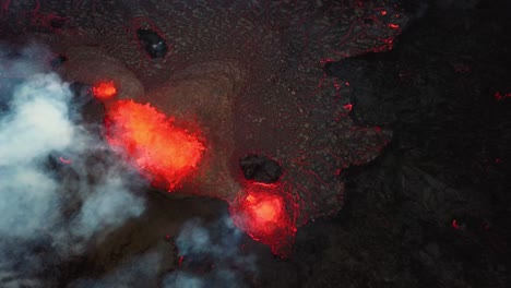 vista aérea superior de magma y lava en erupción en el valle de meradalir, del volcán fagradalsfjall, con humo saliendo